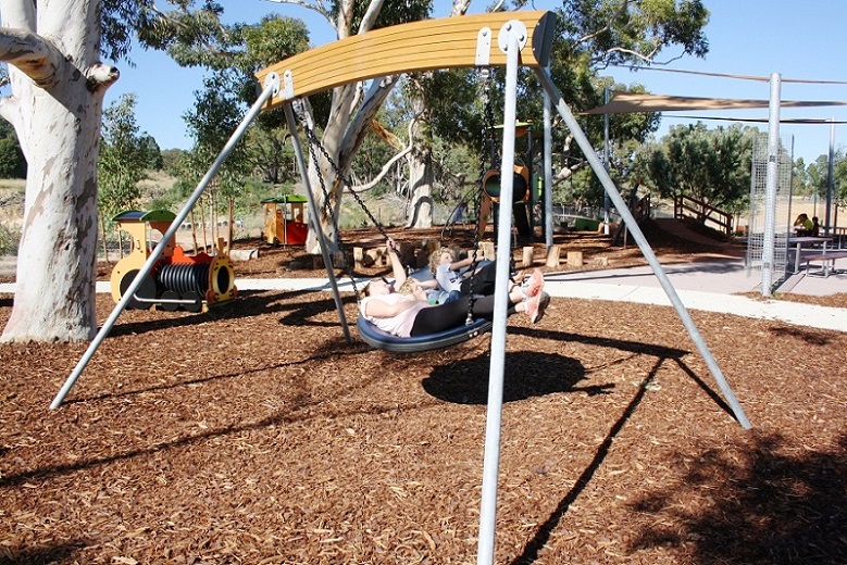 Child playing on a swing at Byford on the Scarp Playground