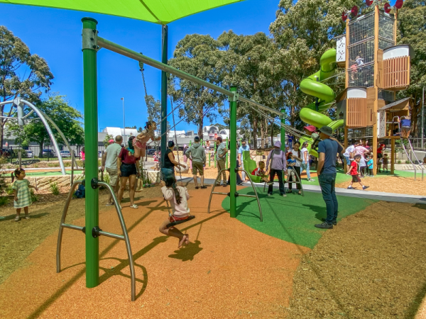 Children playing on Swing set with two flat seats, a cradle seat and an inclusive seat