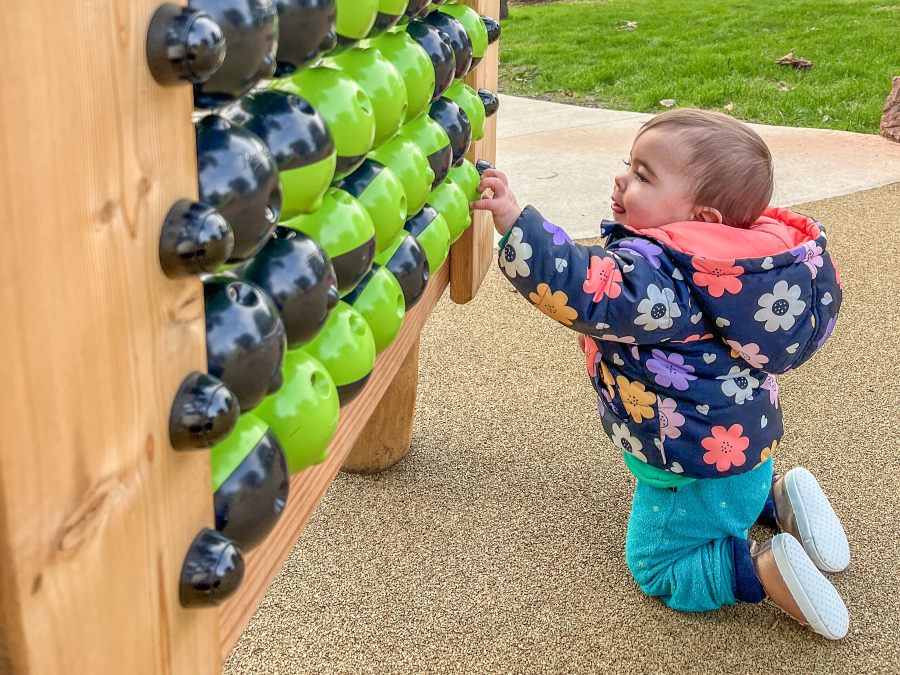 Toddler playing with a manipulative Play Panel