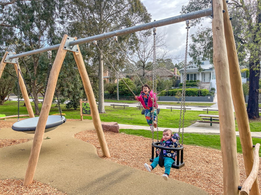 Two children playing on a swing set