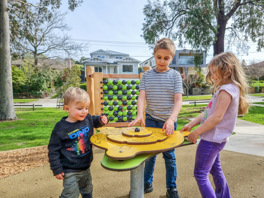 Three children playing with manipulative play table